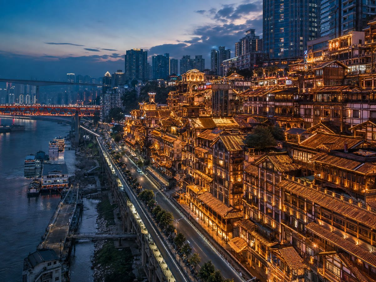 Chongqing's layered riverside skyline and illuminated stilted architecture at dusk