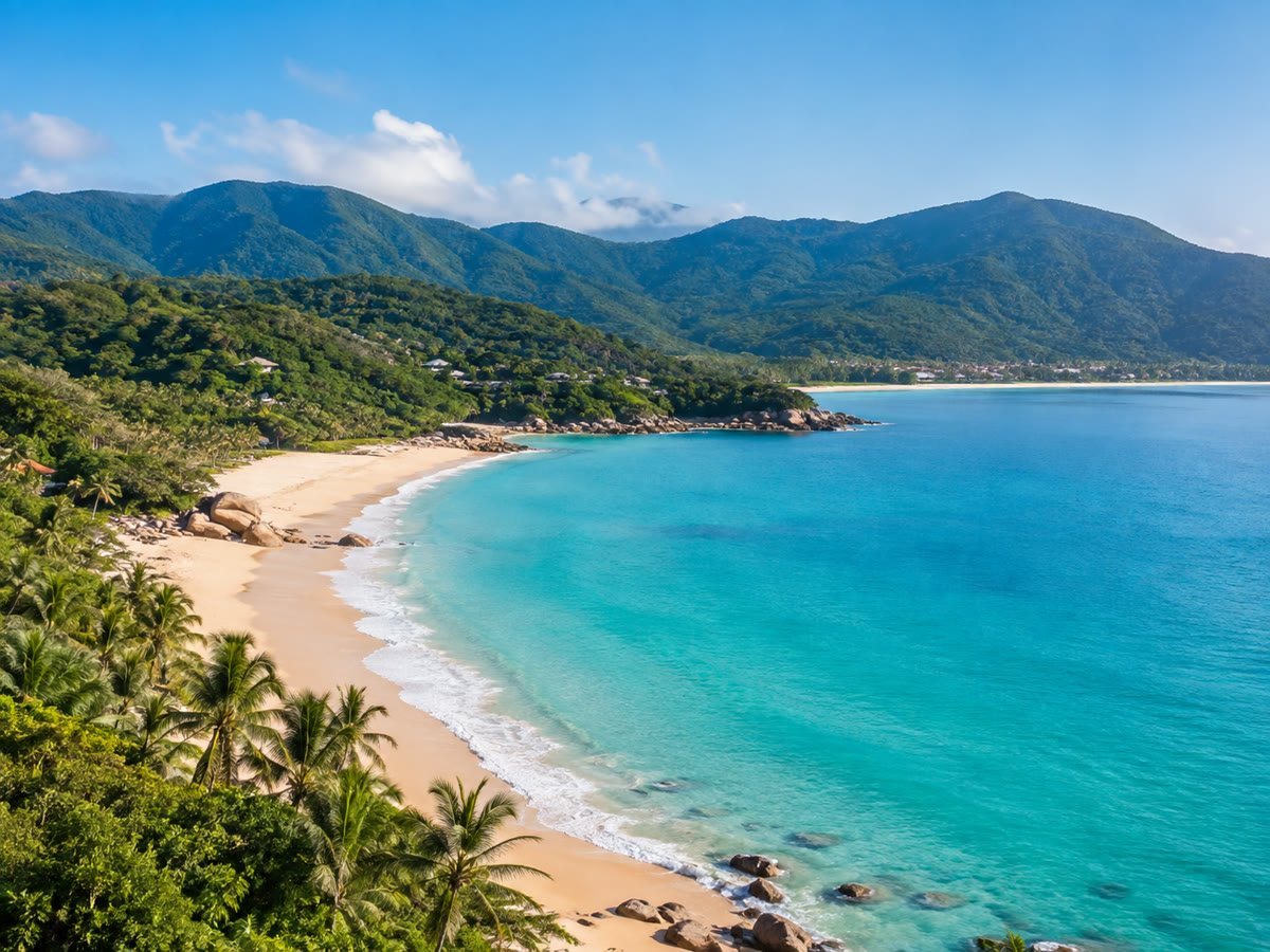 Turquoise water, pale sand and coconut palms along Sanya's tropical coast