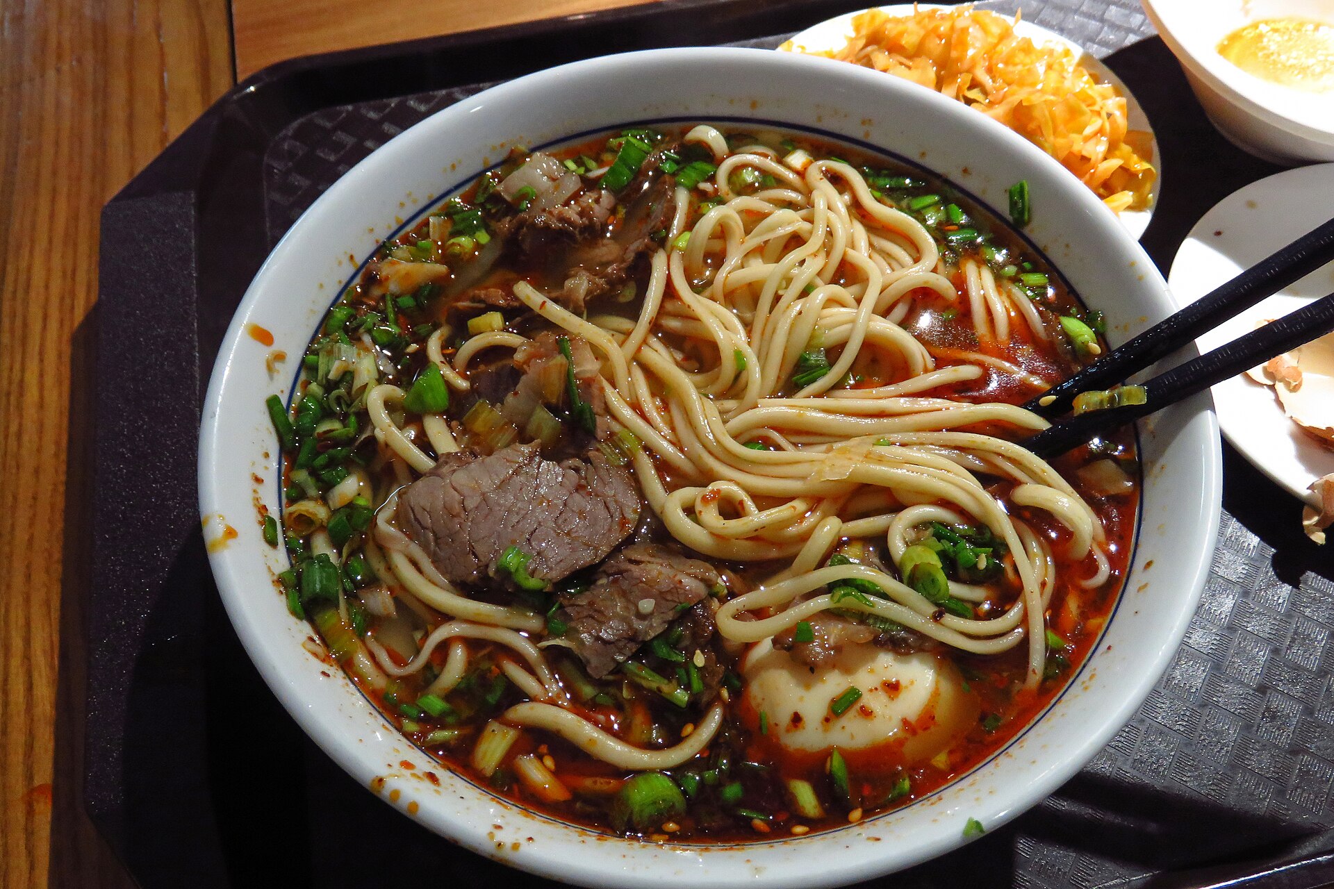 A bowl of beef noodles with sliced beef, greens and an egg in Anning, Lanzhou.